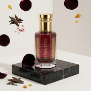 Black Rose Attar, unisex — alcohol-free attar oil by Flora Five: deep garnet oil on black marble with floating rose petals, oud chips, saffron and amber