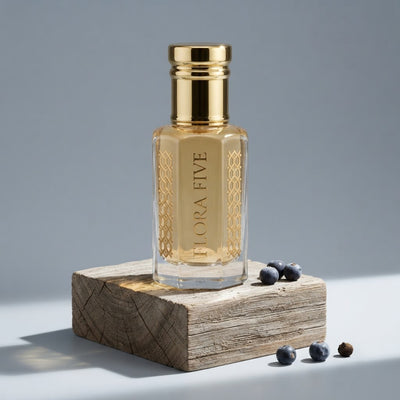Burberry Hero inspired attar for men by Flora Five — alcohol-free perfume oil: gold-capped bottle of pale gold oil on a weathered wood block with juniper berries – 3, 6 and 12 ml