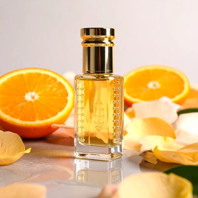 Chanel Coco Mademoiselle inspired attar for women by Flora Five — alcohol-free perfume oil: golden oil in a tall gold-capped bottle with orange halves and yellow petals – 3, 6 and 12 ml