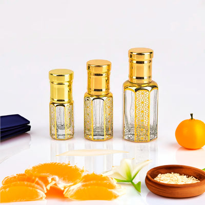 Dior Fahrenheit inspired attar for men by Flora Five — alcohol-free perfume oil: three empty gold-capped bottles of different heights with orange segments, a mandarin and a lily – 3, 6 and 12 ml