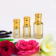 Ehsaas Al Oud, unisex — alcohol-free oud oil (oudh) by Flora Five: three empty gold-trimmed bottles with vanilla pods, red and pink roses and a lily