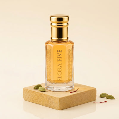 Mukhallat Al Badr Attar by Flora Five — gold-capped bottle of golden oil on a sandstone block with cardamom pods – 3, 6 and 12 ml