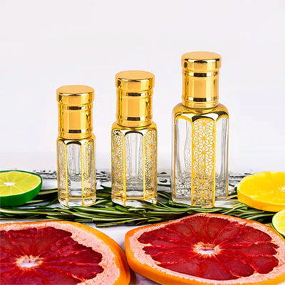 Mont Blanc Legend inspired attar for men — alcohol-free perfume oil by Flora Five: three empty gold-patterned bottles with grapefruit, lime, lemon and rosemary
