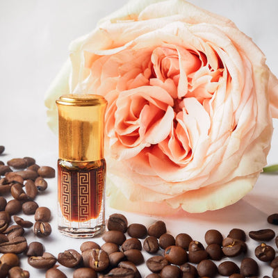Coffee Rose Attar by Flora Five — small gold-capped bottle of dark brown oil with a Greek-key print beside a peach rose and coffee beans – 3, 6 and 12 ml