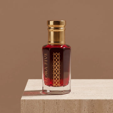 Coffee Rose Attar by Flora Five — deep rose-brown oil on a travertine block against a mocha backdrop