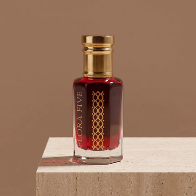 Coffee Rose Attar by Flora Five — deep rose-brown oil on a travertine block against a mocha backdrop