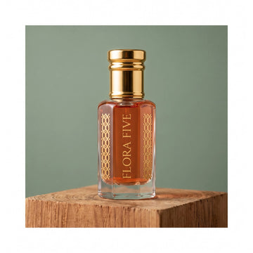 Diptyque Tam Dao inspired unisex attar — alcohol-free perfume oil by Flora Five: amber oil in a gold-capped bottle on a cedar block against a sage backdrop