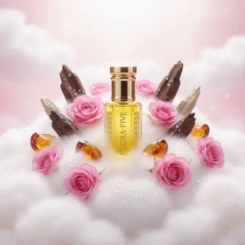 Perfume bottle labeled 'Flora Five' surrounded by pink roses and amber drops on a soft white background.