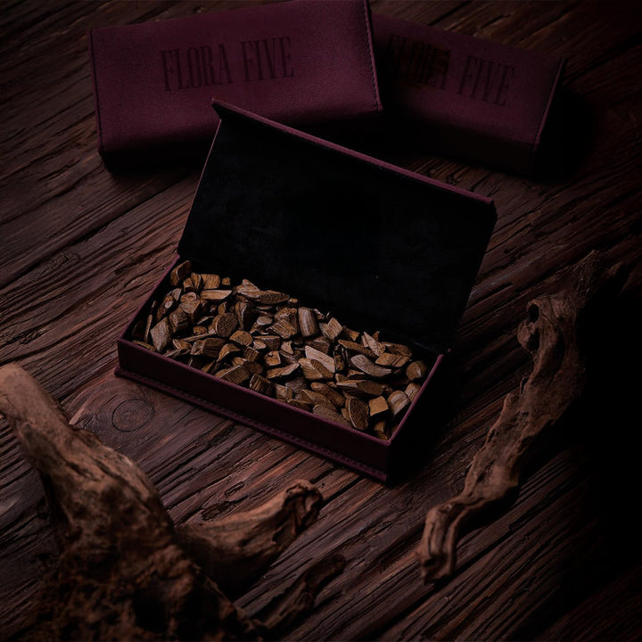 Faakhir bakhoor chips by Flora Five presented in a luxury branded box with premium oud wood incense chips on a rustic wooden surface.