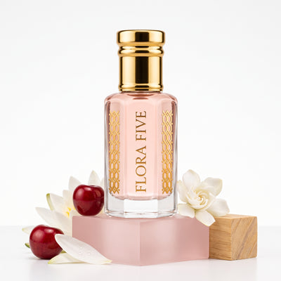 Bath & Body Works Pink Chiffon inspired attar for women by Flora Five — alcohol-free perfume oil: gold-capped bottle of pale pink oil on a pink block with cherries, gardenia and a wooden cube – 3, 6 and 12 ml