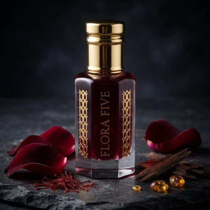 Black Rose Attar by Flora Five — gold-capped bottle of deep garnet oil on dark stone with rose petals, saffron and oud chips – 3, 6 and 12 ml