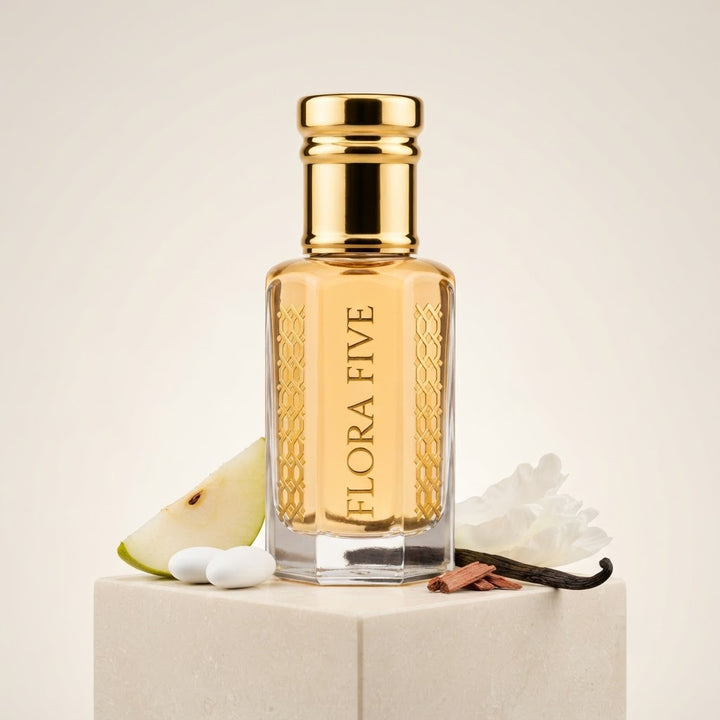 Burberry Brit for Women Inspired Attar by Flora Five — gold-capped bottle of golden yellow oil on a white block with a pear slice, white flowers and a vanilla pod – 3, 6 and 12 ml