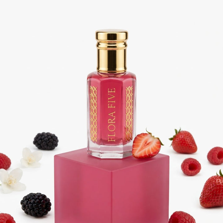 Burberry Her Inspired Attar by Flora Five — gold-capped bottle of raspberry-pink oil on a pink block with strawberries, blackberries and jasmine – 3, 6 and 12 ml
