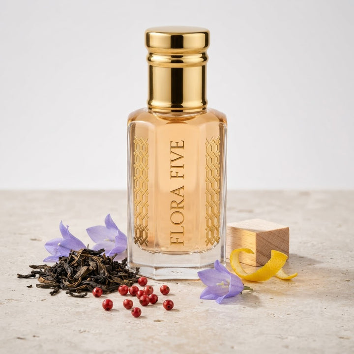 Burberry The Beat for Women Inspired Attar by Flora Five — gold-capped bottle of pale apricot oil on stone with tea leaves, pink pepper and bellflowers – 3, 6 and 12 ml