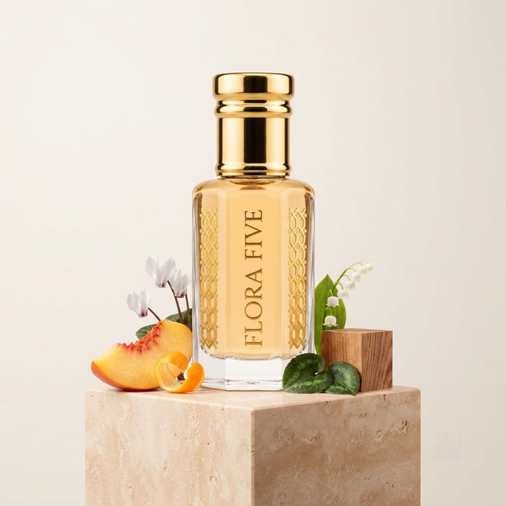 Burberry Weekend for Women Inspired Attar by Flora Five — gold-capped bottle of pale apricot oil on a travertine block with peach, cyclamen and lily of the valley – 3, 6 and 12 ml