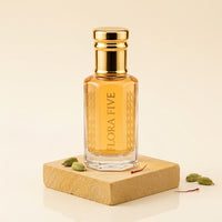 Mukhallat Al Badr Attar by Flora Five — gold-capped bottle of golden oil on a sandstone block with cardamom pods – 3, 6 and 12 ml