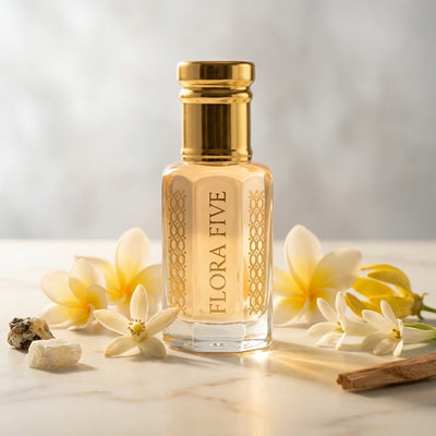 Prada La Femme inspired attar for women by Flora Five — alcohol-free perfume oil: gold-capped bottle of pale peach oil on marble with frangipani, iris root and sandalwood – 3, 6 and 12 ml