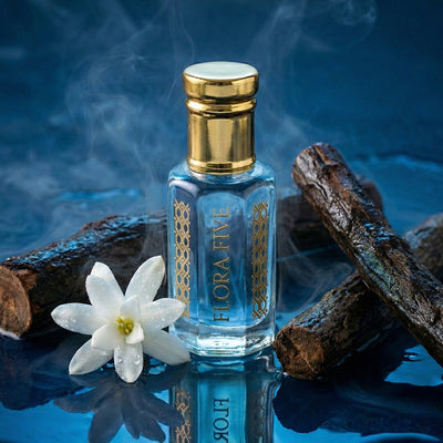 Rasasi Hawas Ice inspired attar for men by Flora Five — alcohol-free perfume oil: gold-capped bottle of pale blue oil on blue with misty smoke, a white flower and dark wood – 3, 6 and 12 ml
