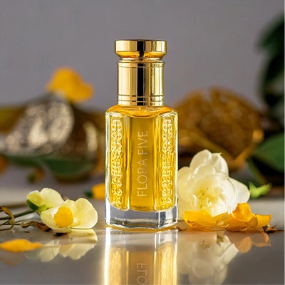 White Arabian Oud by Flora Five — gold-capped bottle of golden oil on a mirror with white and yellow flowers and an oud chip – 3, 6 and 12 ml