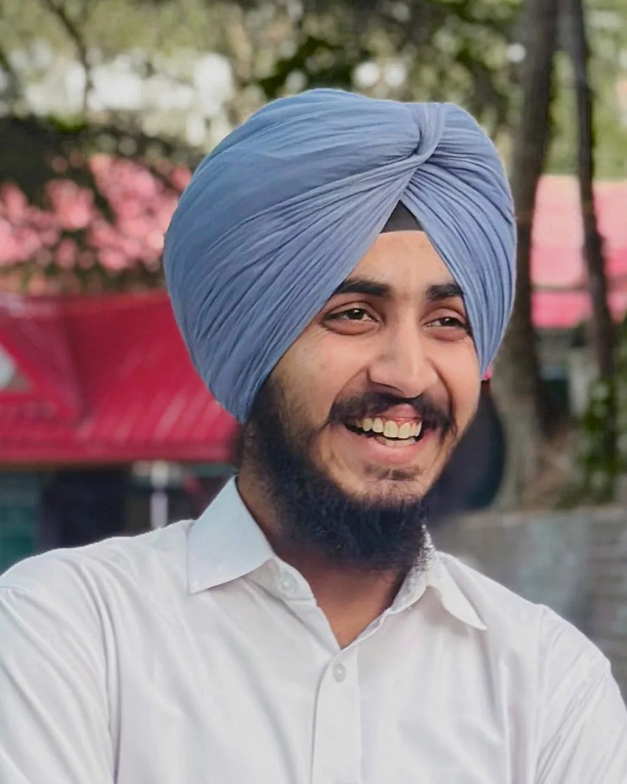Armaan Singh, founder of Flora Five, smiling in a powder-blue turban and white shirt