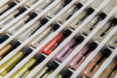 The Signature Sample Set by Flora Five — rows of small glass sample vials of different coloured oils in a tray