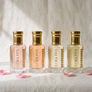 Bloom & Musk Combo unisex — four alcohol-free attar oils by Flora Five in blush, peach, ivory and pale gold bottles on ivory linen with rose petals