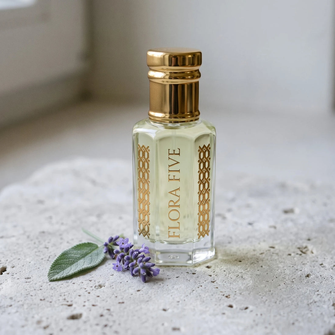 CK Eternity inspired attar for men — alcohol-free perfume oil by Flora Five: pale yellow oil in a gold-capped bottle on stone with lavender and a sage leaf