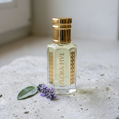 CK Eternity inspired attar for men — alcohol-free perfume oil by Flora Five: pale yellow oil in a gold-capped bottle on stone with lavender and a sage leaf