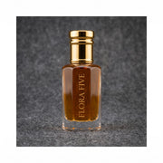 Dunhill Black inspired attar for men — alcohol-free perfume oil by Flora Five: amber oil in a gold-capped bottle against a charcoal felt backdrop
