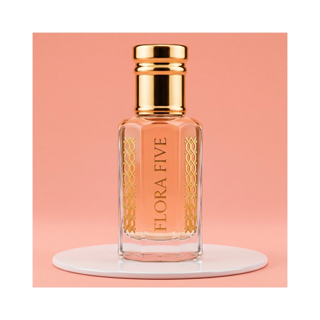 Escada Kiss Land inspired attar for women — alcohol-free perfume oil by Flora Five: peach oil in a gold-capped bottle on a white plinth against coral pink