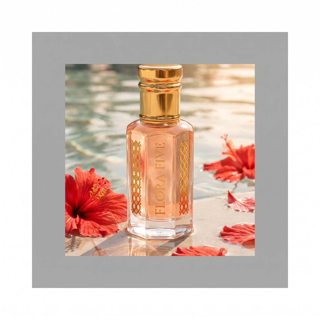 Escada Kiss Land inspired attar by Flora Five — bottle at a sunlit pool edge with red hibiscus flowers and petals