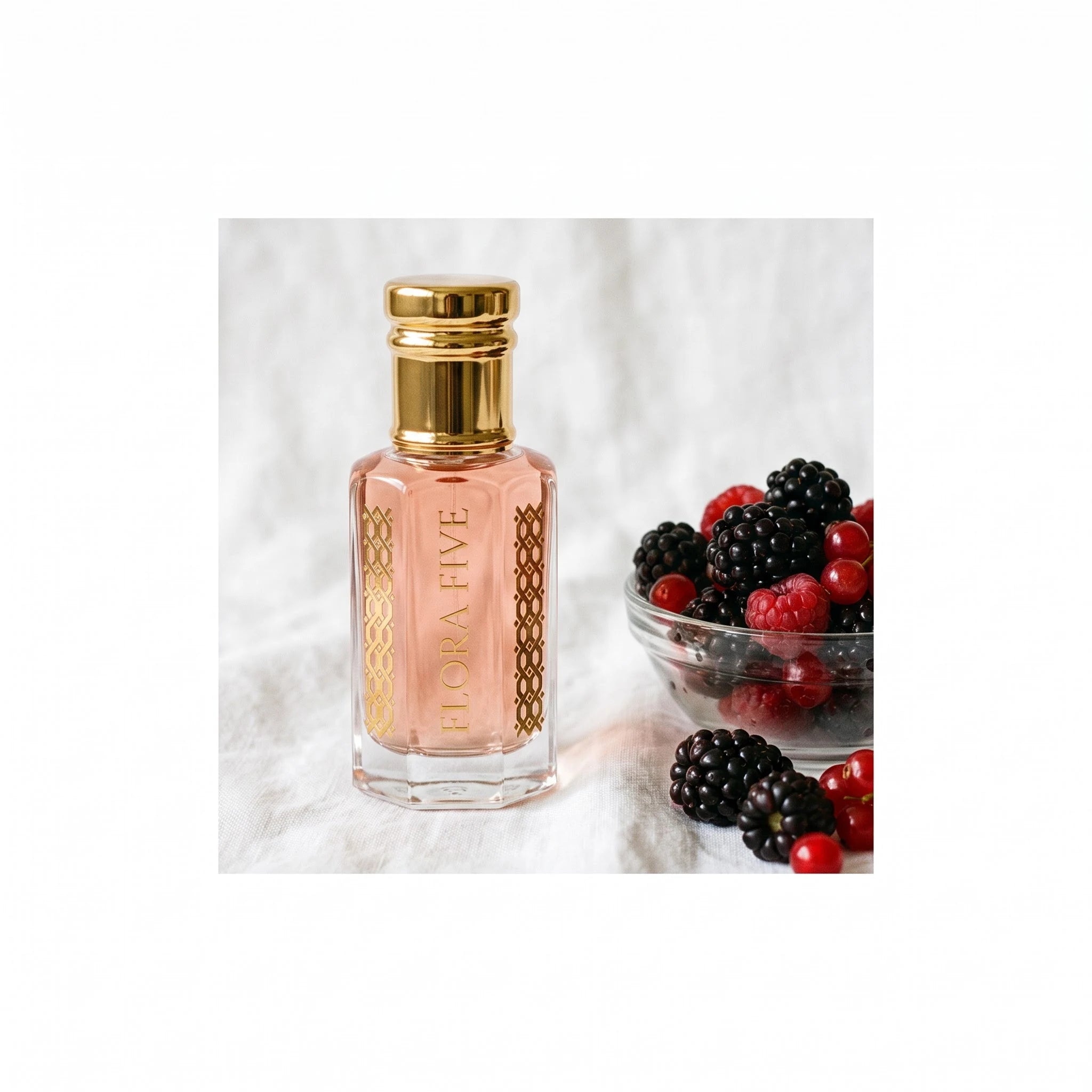 Gucci Paris Inspired Attar by Flora Five — bottle on white linen beside a bowl of blackberries, raspberries and redcurrants