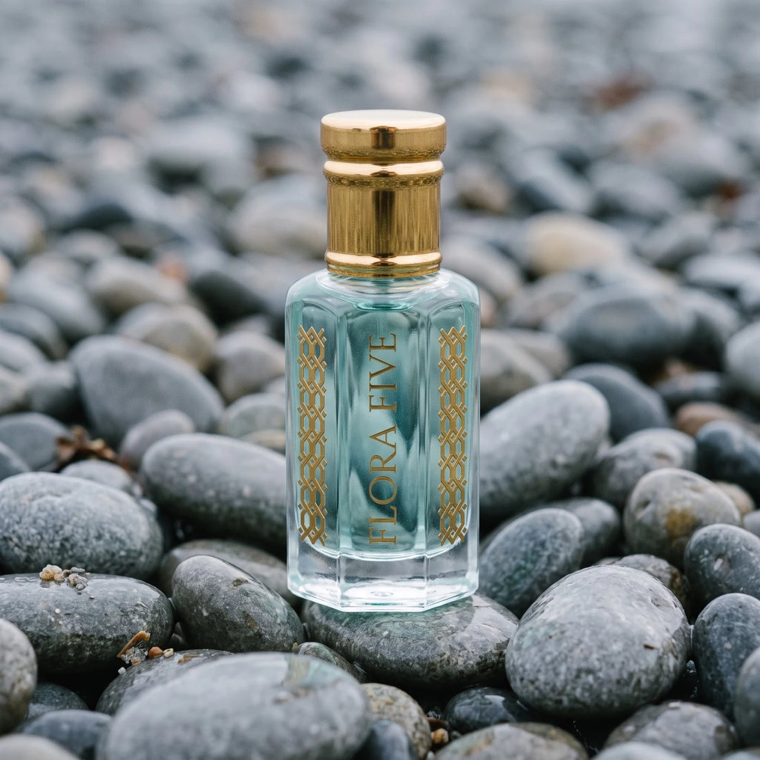 Hugo Boss Bottled Marine inspired attar for men — alcohol-free perfume oil by Flora Five: pale aqua oil in a gold-capped bottle on wet beach pebbles