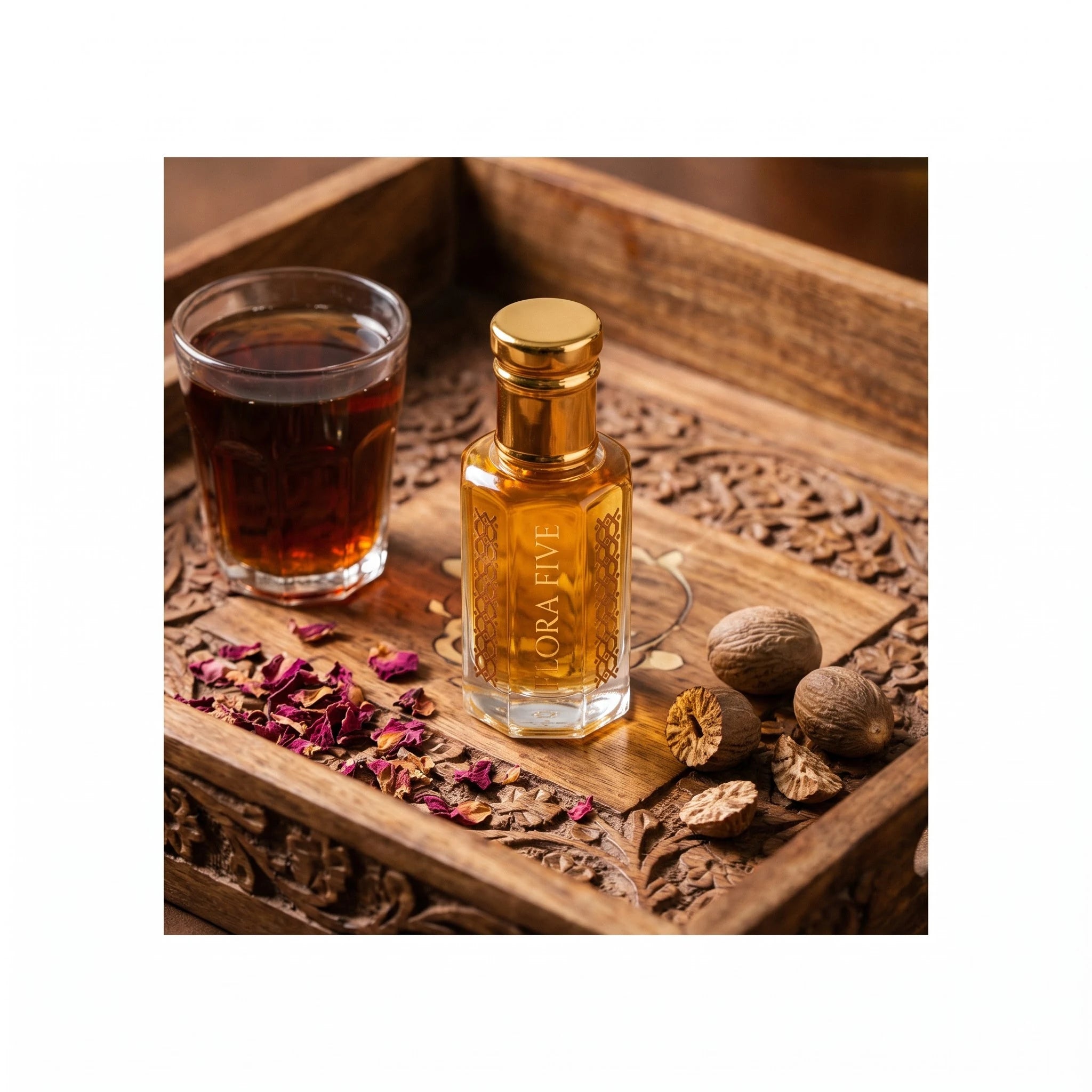 Kasturi Attar by Flora Five, alcohol-free attar oil: bottle with black tea, rose petals and nutmeg on a carved tray – 3, 6 and 12 ml