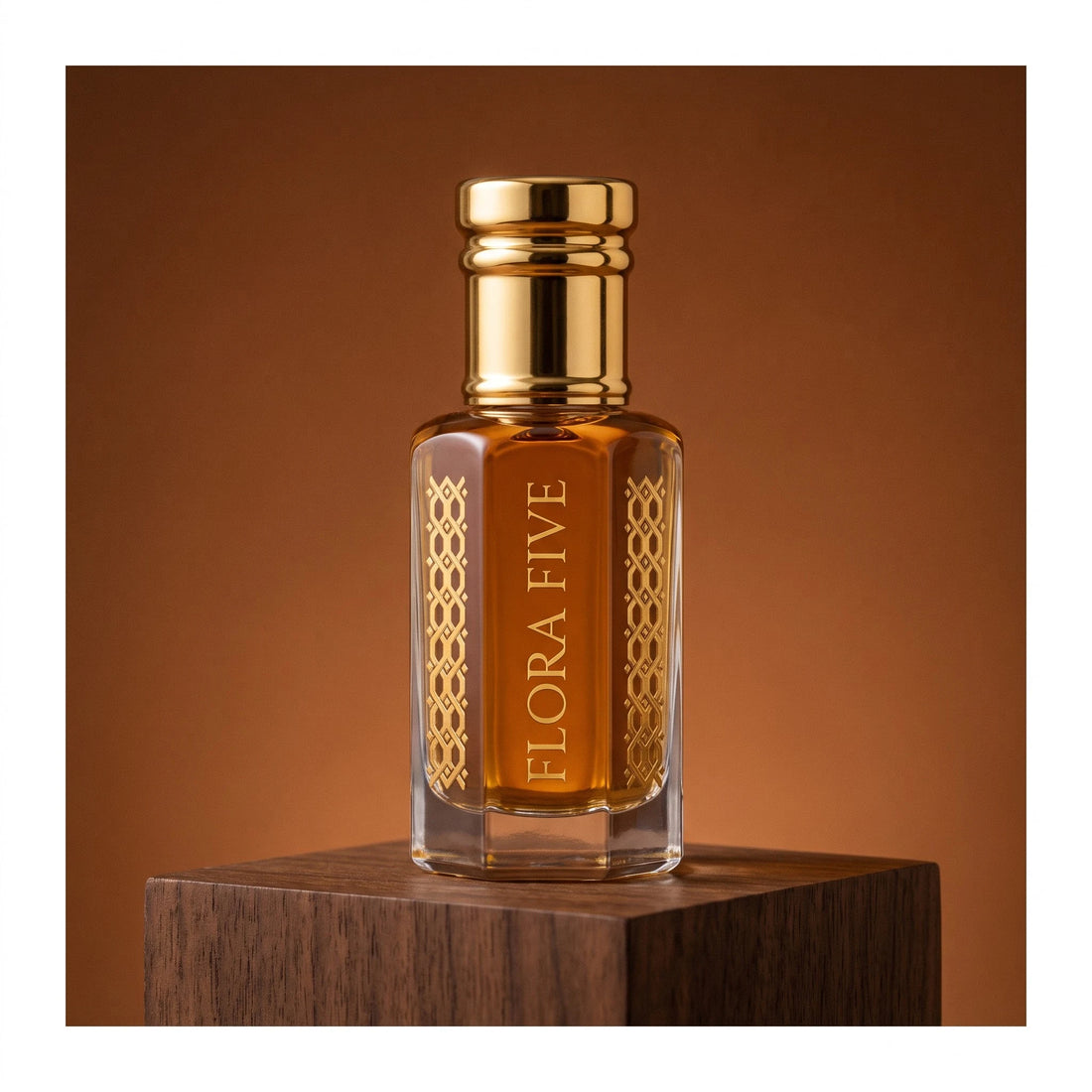 Khulasatal Oud, unisex — alcohol-free oud oil (oudh) by Flora Five: deep amber oil in a gold-capped bottle on walnut against a cognac backdrop