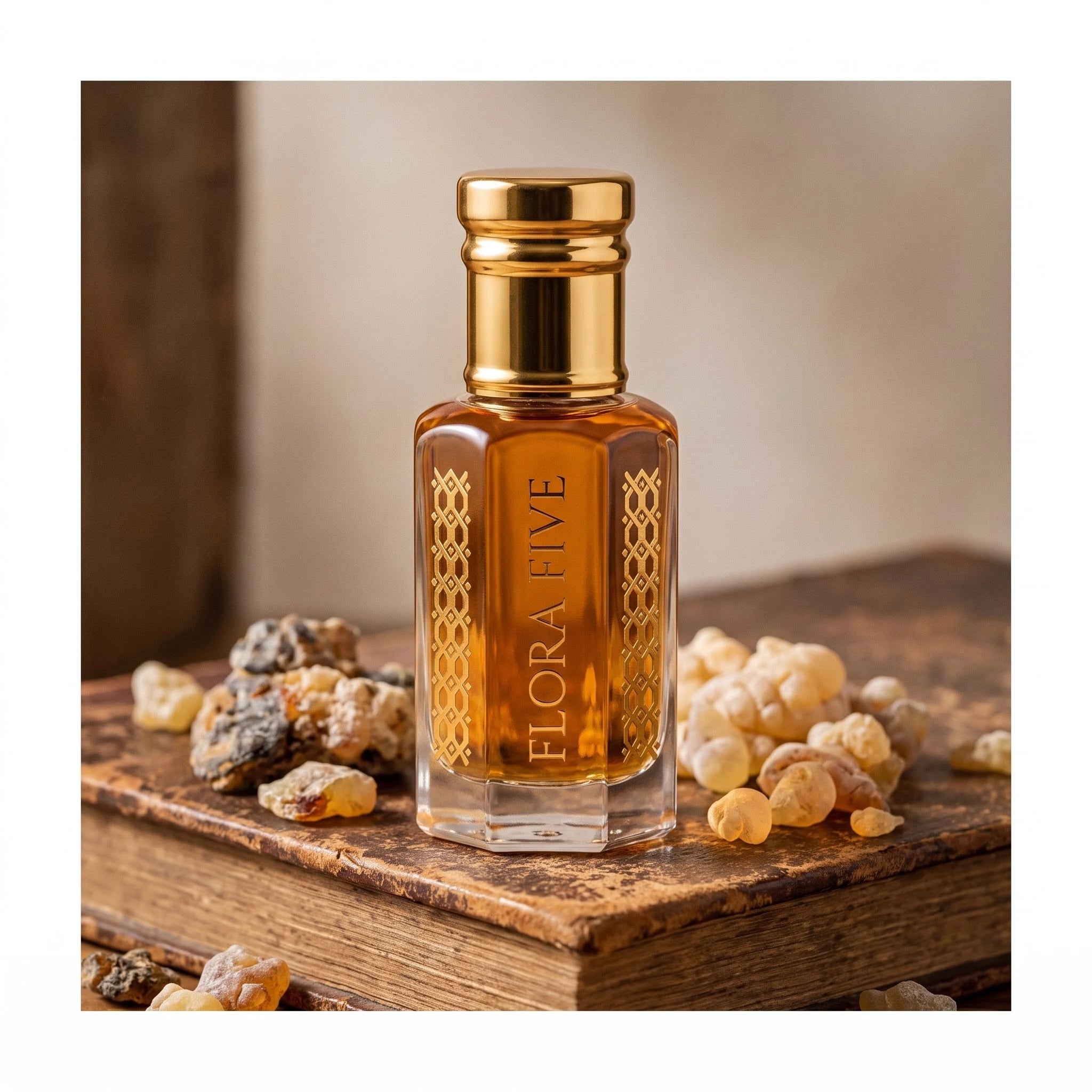 Khulasatal Oud by Flora Five — bottle on an old leather-bound book with frankincense and labdanum resin
