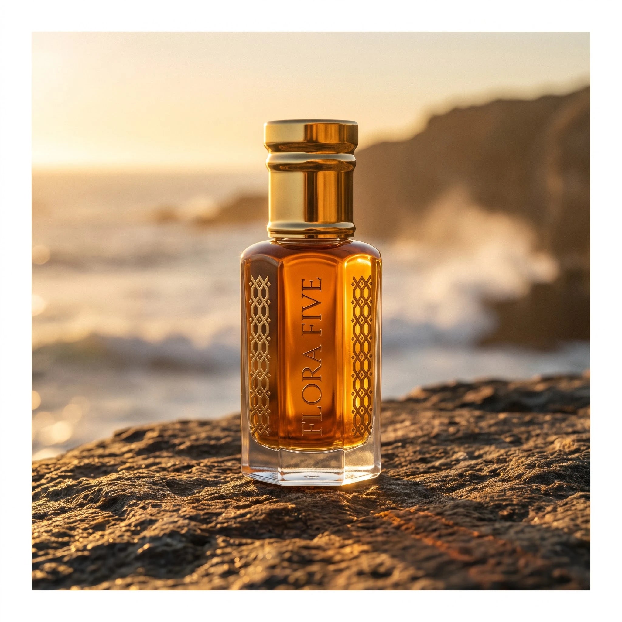 Khulasatal Oud by Flora Five — amber oud oil bottle on a sea cliff rock at golden hour with waves behind