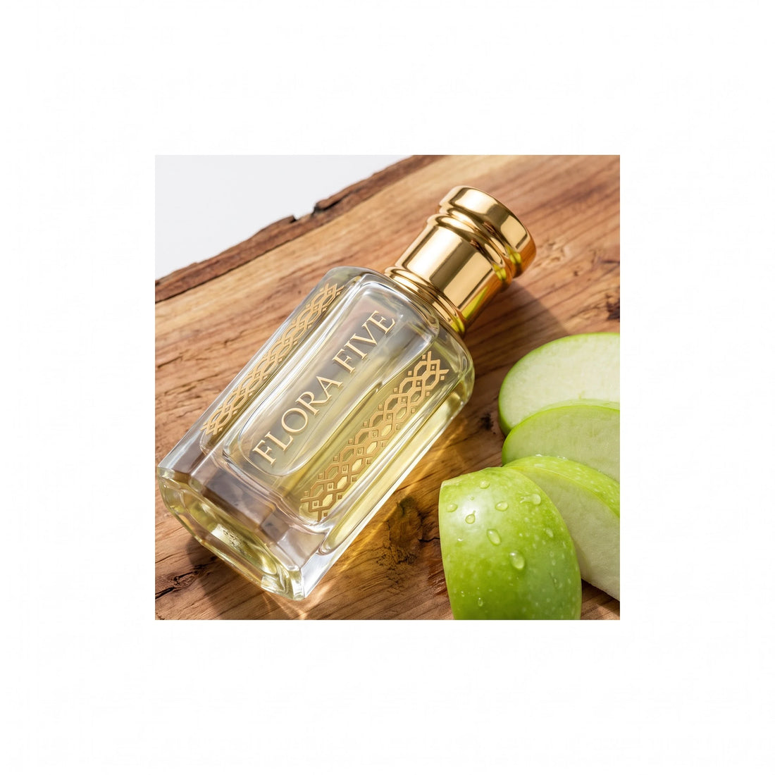 Lacoste Red inspired attar by Flora Five — bottle lying on rough cedar wood beside sliced green apple