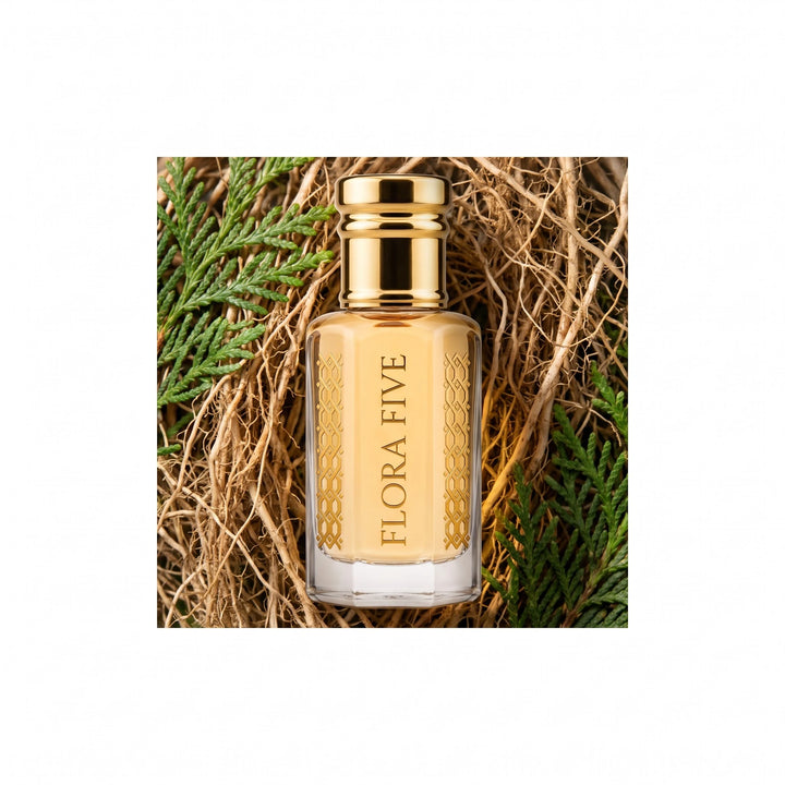 Lacoste Red inspired attar by Flora Five — bottle nestled in vetiver roots and green thuja sprigs