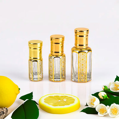 Dolce & Gabbana Light Blue inspired attar for women by Flora Five — alcohol-free perfume oil: three empty gold-capped bottles of different heights with lemon, a lemon slice and jasmine – 3, 6 and 12 ml