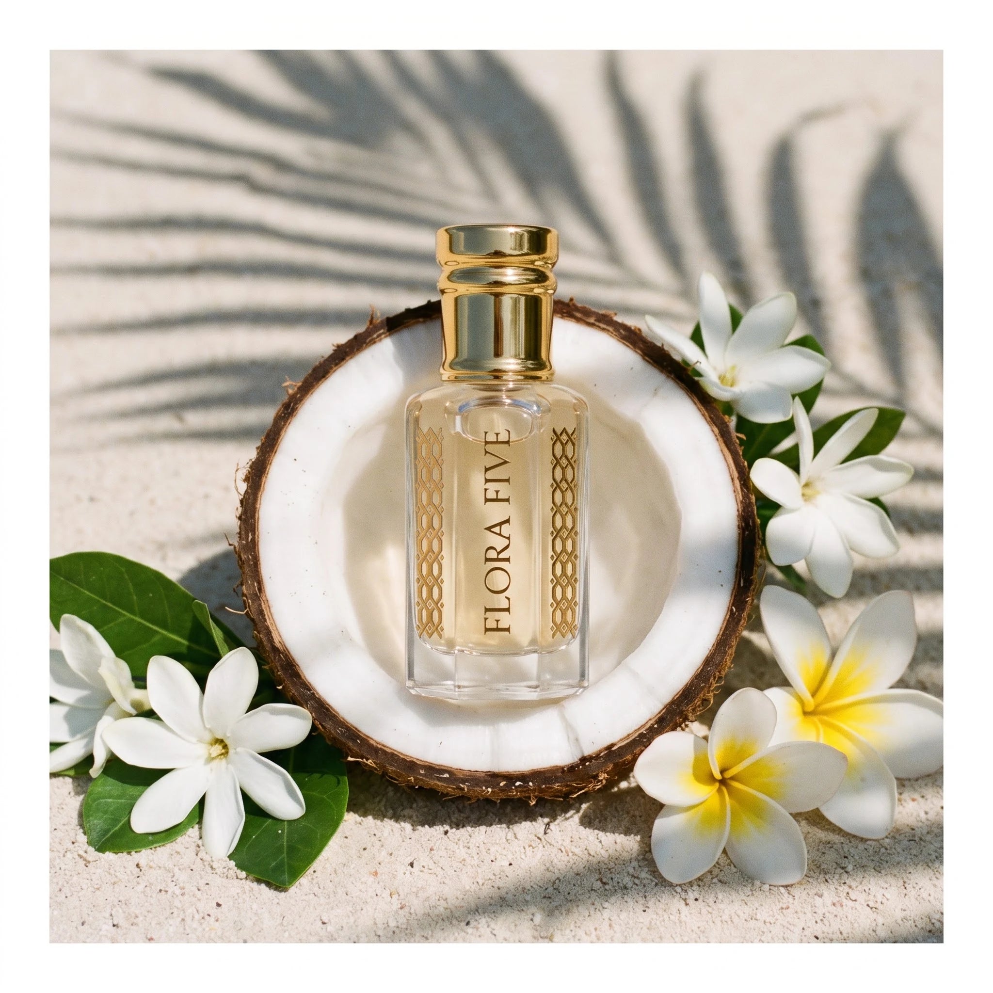 Mancera Coco Vanilla inspired attar by Flora Five — bottle set in a halved coconut on sand with tiare and frangipani flowers in palm shade