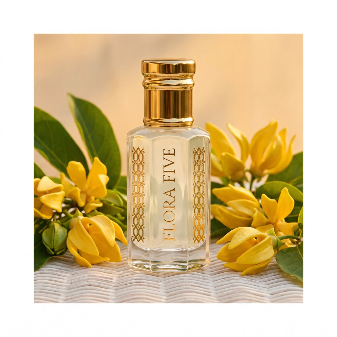 Mancera Coco Vanilla inspired attar by Flora Five — bottle on rattan among yellow ylang-ylang flowers in warm evening light