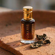 Oud Patchouli unisex — alcohol-free oud oil (oudh) by Flora Five: dark brown oil on sunlit terracotta with dried patchouli leaves