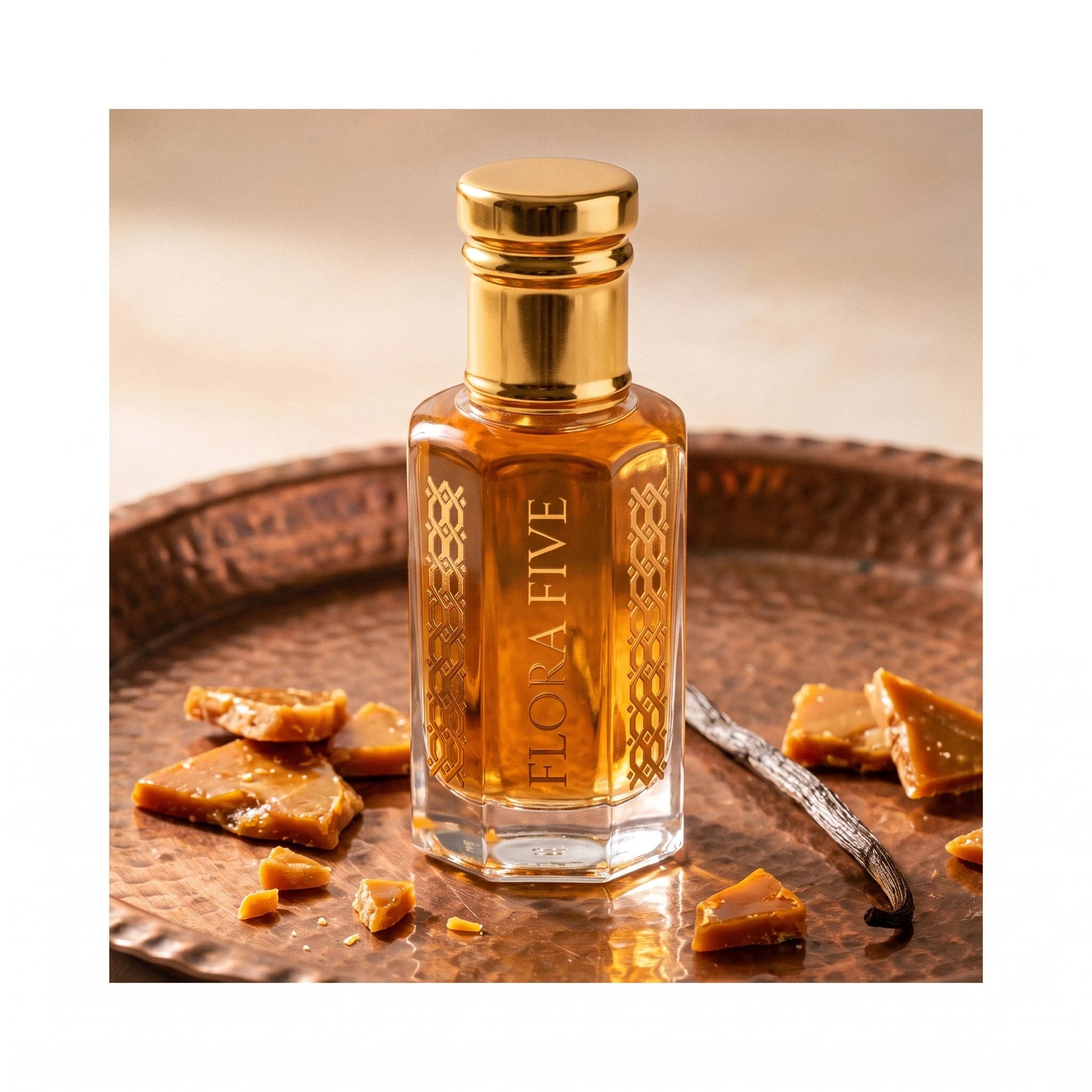 Oud Saffron by Flora Five — bottle on a hammered copper tray with praline brittle and a vanilla pod