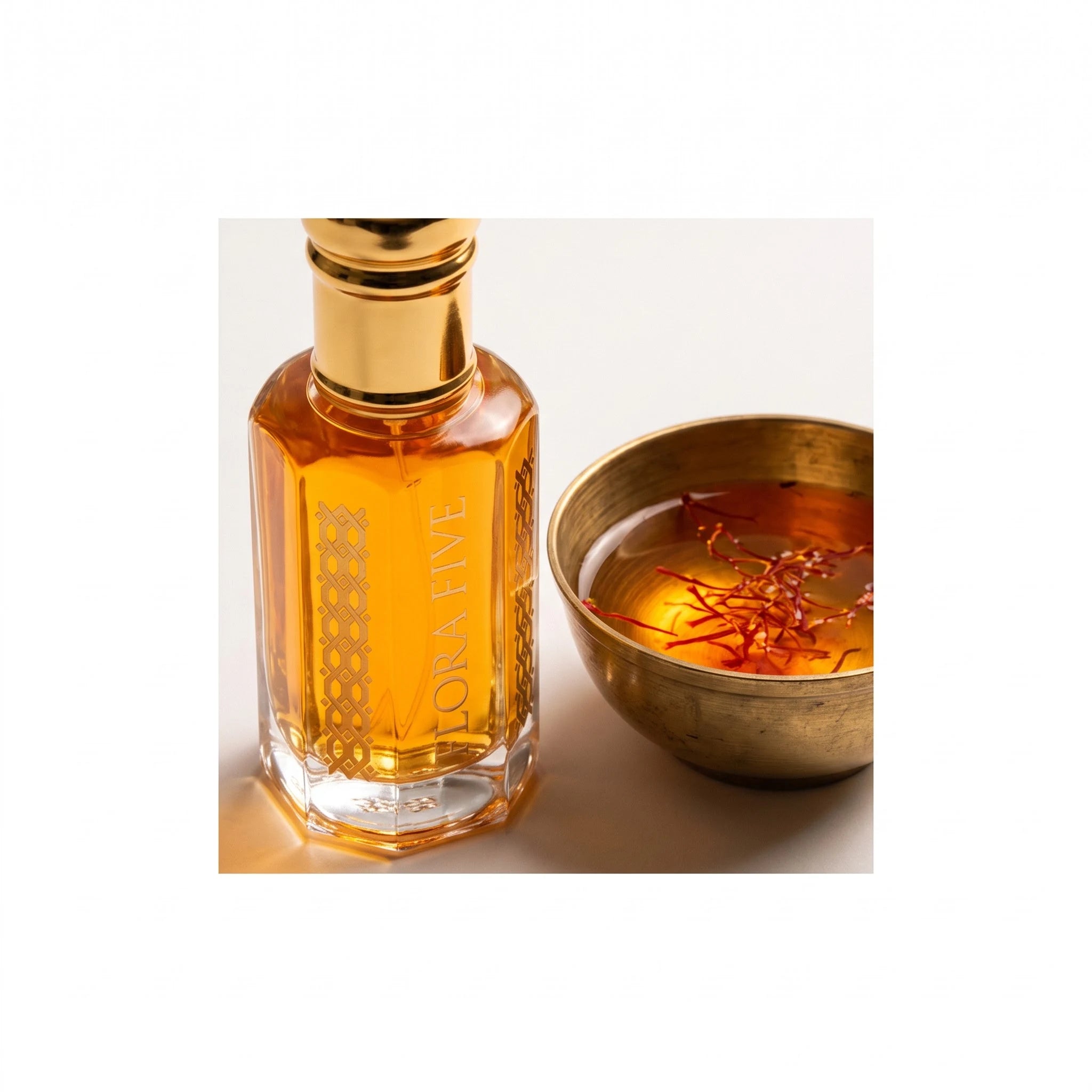 Oud Saffron by Flora Five — close-up of the amber oud oil beside saffron threads steeping in a brass bowl