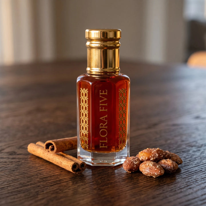 Paco Rabanne Black XS inspired attar for men — alcohol-free attar oil by Flora Five: reddish amber oil on dark oak with cinnamon sticks and pralines