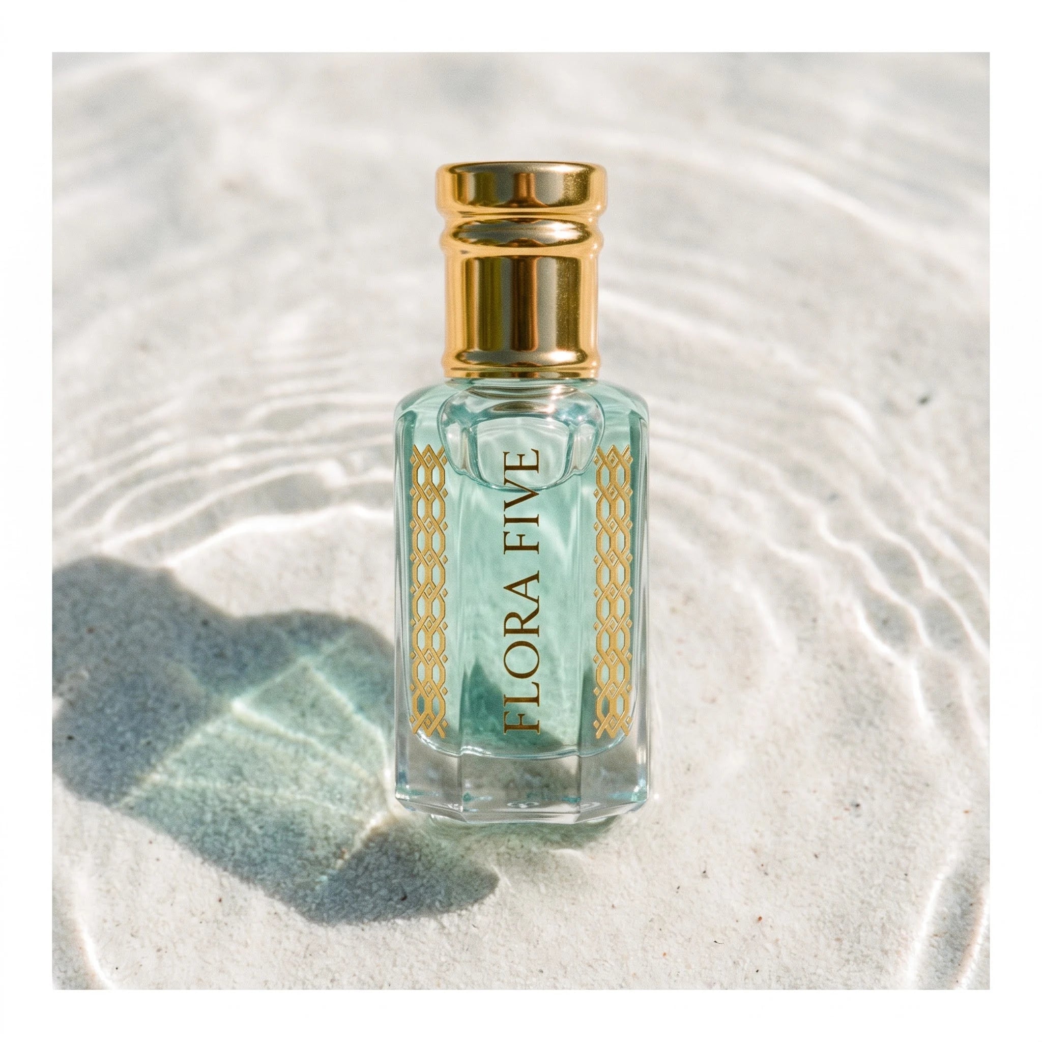 Rasasi Hawas Inspired Attar by Flora Five — aqua oil bottle standing in clear rippling water over white sand