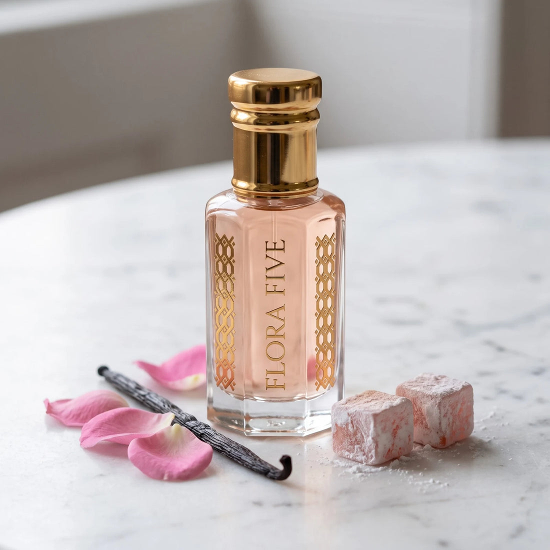 Rose Vanilla Attar by Flora Five — blush pink oil on marble with rose petals, a vanilla pod and Turkish delight