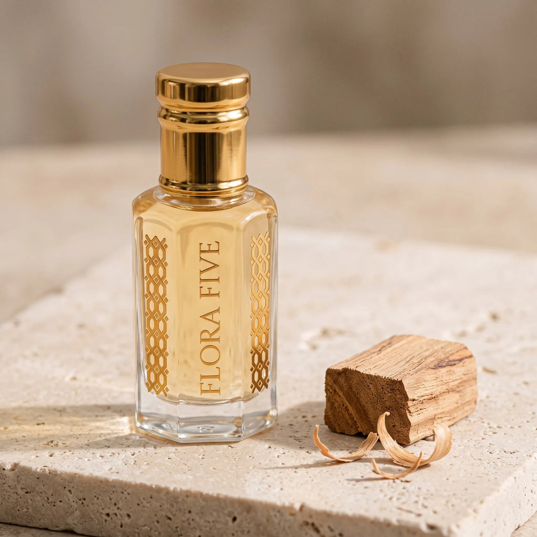Sandalwood Attar, unisex — alcohol-free attar oil by Flora Five: pale golden oil on travertine with a sandalwood block and curled shavings