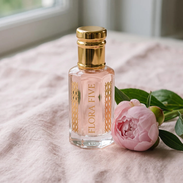 Victoria's Secret Bombshell inspired attar by Flora Five: blush pink oil bottle on pink linen with a peony
